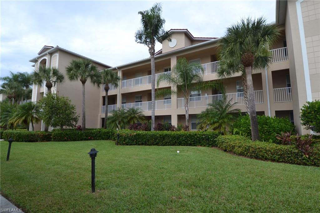 2750 Cypress Trace Circle, Unit 2636 Naples, FL 34119 - Photo 1 of 26 a front view of a house with a yard