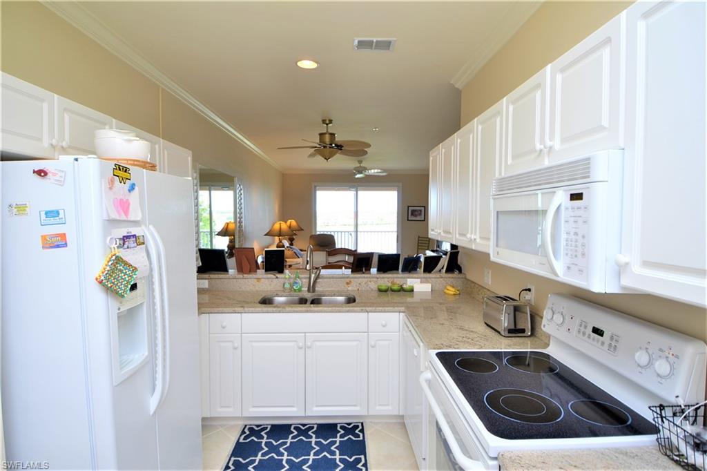 2750 Cypress Trace Circle, Unit 2636 Naples, FL 34119 - Photo 11 of 26 a kitchen with a sink a stove and refrigerator