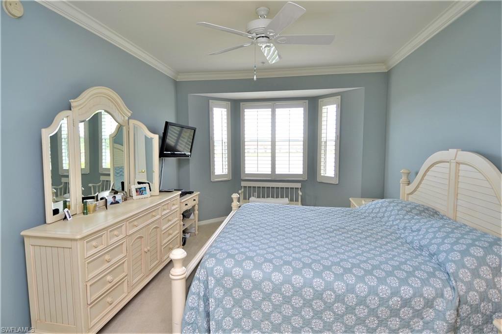 2750 Cypress Trace Circle, Unit 2636 Naples, FL 34119 - Photo 15 of 26 a bedroom with a bed a mirror and a large window
