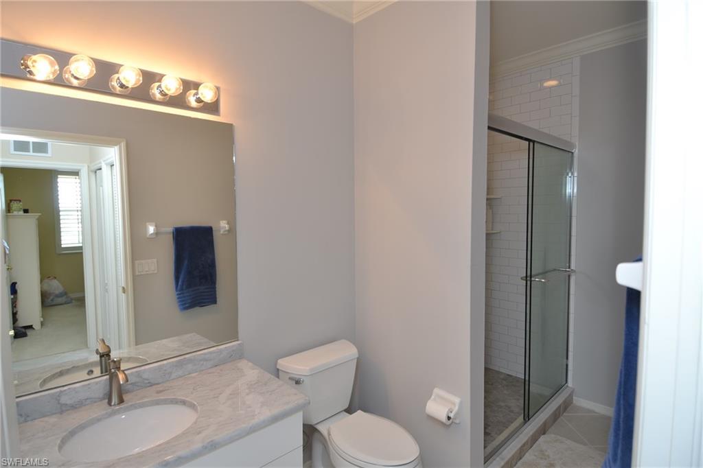2750 Cypress Trace Circle, Unit 2636 Naples, FL 34119 - Photo 19 of 26 a bathroom with a granite countertop sink toilet and shower