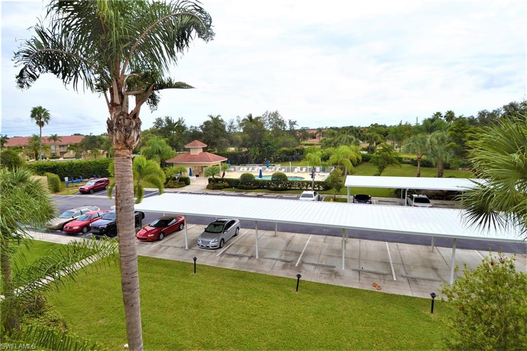 2750 Cypress Trace Circle, Unit 2636 Naples, FL 34119 - Photo 20 of 26 a view of swimming pool with a table and chairs plants