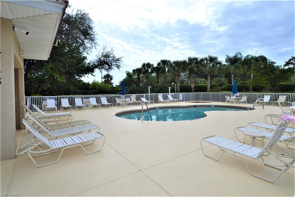 2750 Cypress Trace Circle, Unit 2636 Naples, FL 34119 - Photo 21 of 26 an outdoor sitting area with swimming pool and outdoor seating