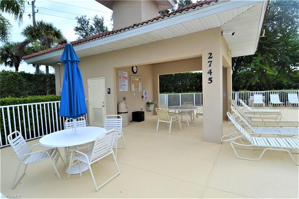 2750 Cypress Trace Circle, Unit 2636 Naples, FL 34119 - Photo 22 of 26 a view of a patio with a table and chairs