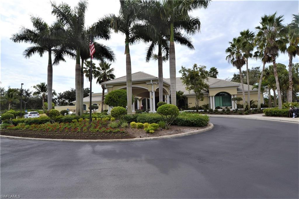 2750 Cypress Trace Circle, Unit 2636 Naples, FL 34119 - Photo 23 of 26 a front view of a house with a garden and trees