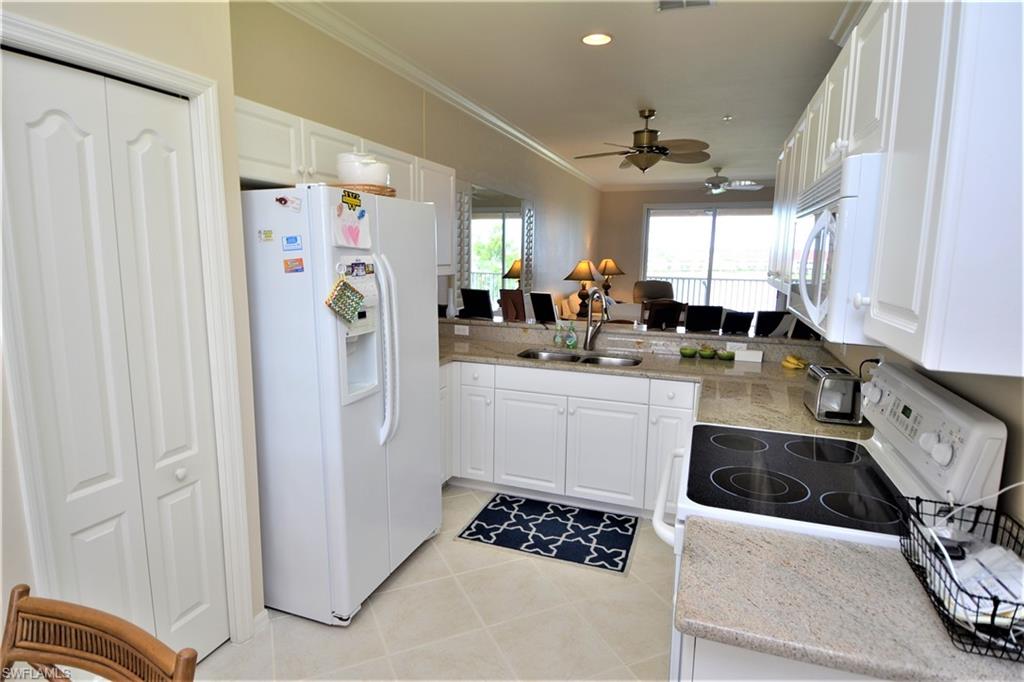 2750 Cypress Trace Circle, Unit 2636 Naples, FL 34119 - Photo 8 of 26 a kitchen with a sink a stove a refrigerator and cabinets