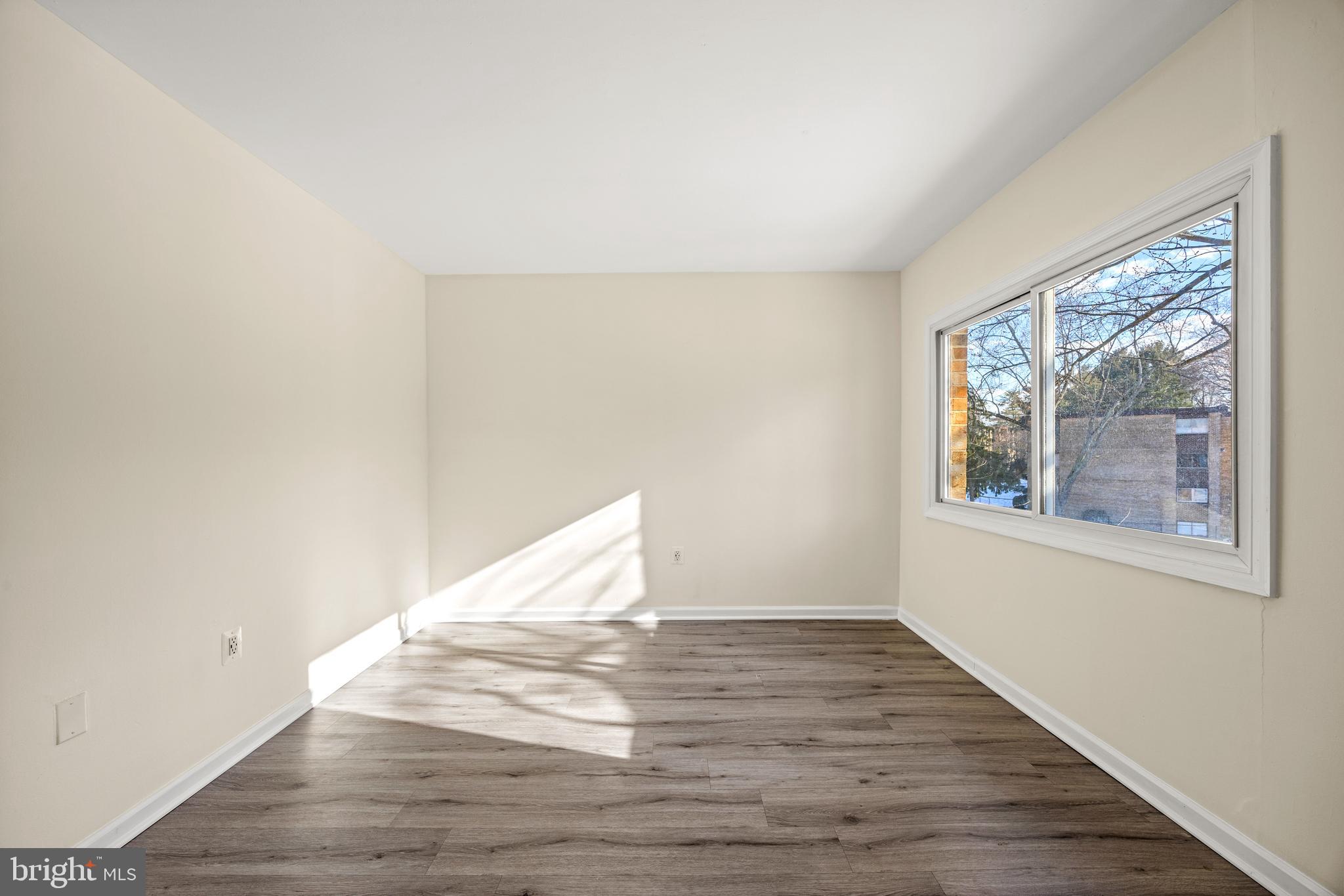3736 Bel Pre Road, Unit 37367 Silver Spring, MD 20906 - Photo 16 of 27 a view of an empty room with wooden floor and a window