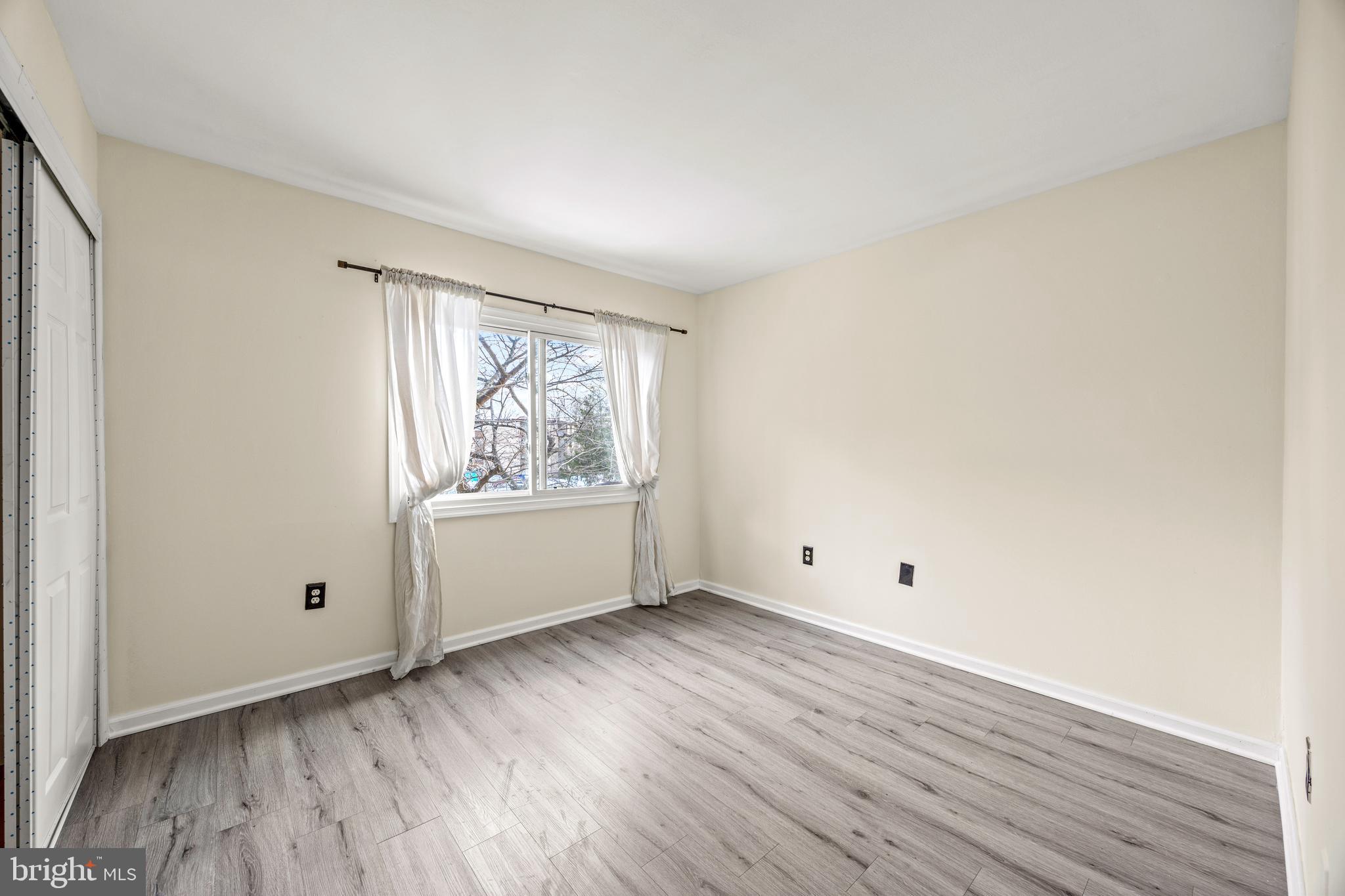 3736 Bel Pre Road, Unit 37367 Silver Spring, MD 20906 - Photo 22 of 27 an empty room with wooden floor and windows