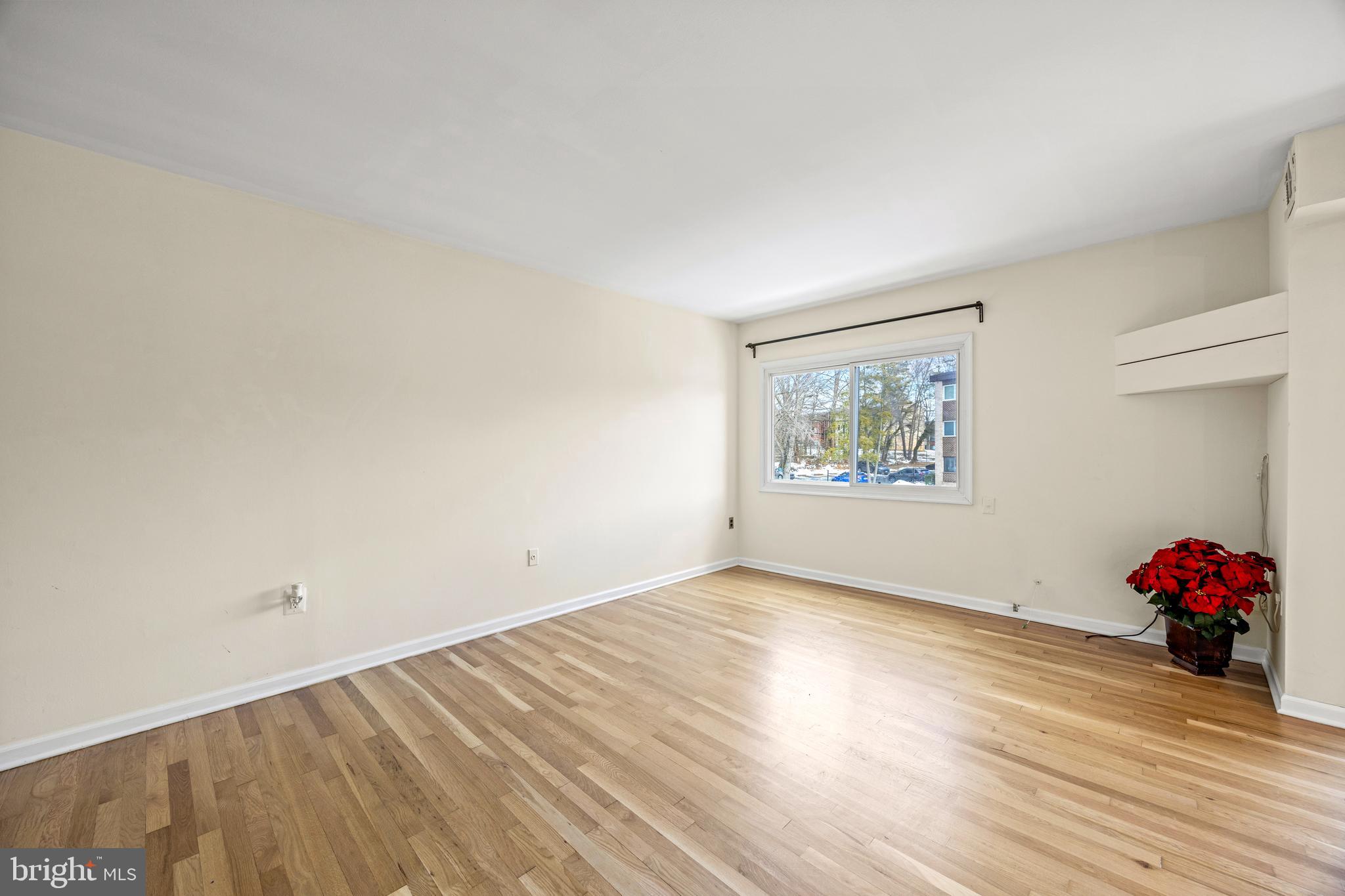 3736 Bel Pre Road, Unit 37367 Silver Spring, MD 20906 - Photo 5 of 27 a view of an empty room with wooden floor and a window