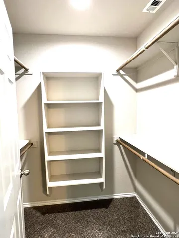 a view of walk in closet with empty racks