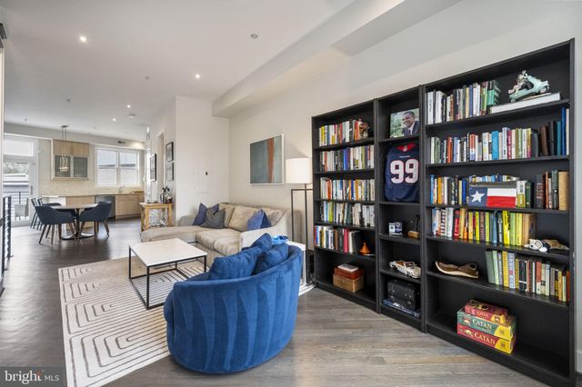 a living room with furniture and a book shelf