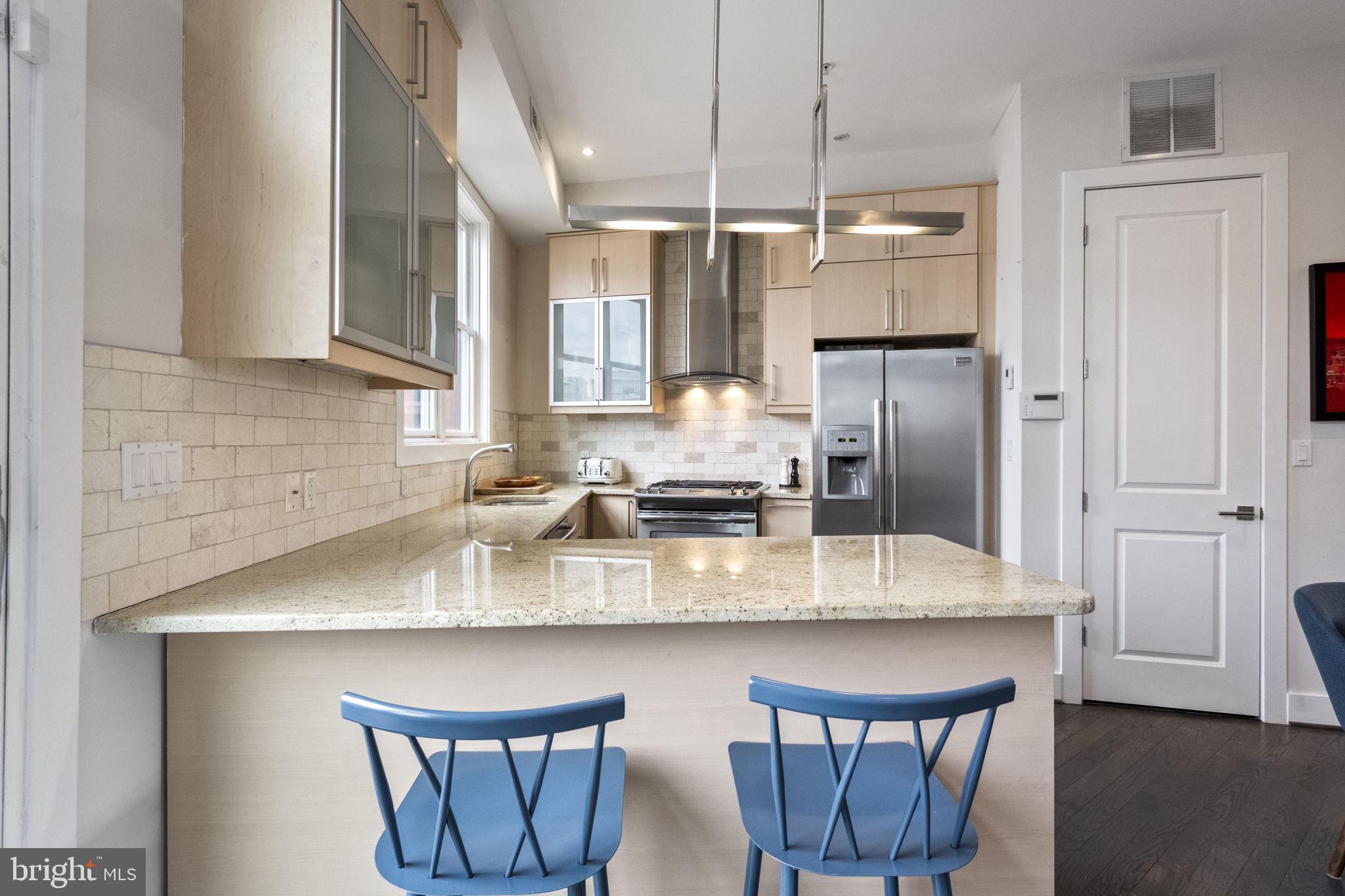 501 Rhode Island Avenue Northwest, Unit 2 Washington, DC 20001 - Photo 7 of 21 a kitchen with stainless steel appliances granite countertop a kitchen island a table and chairs