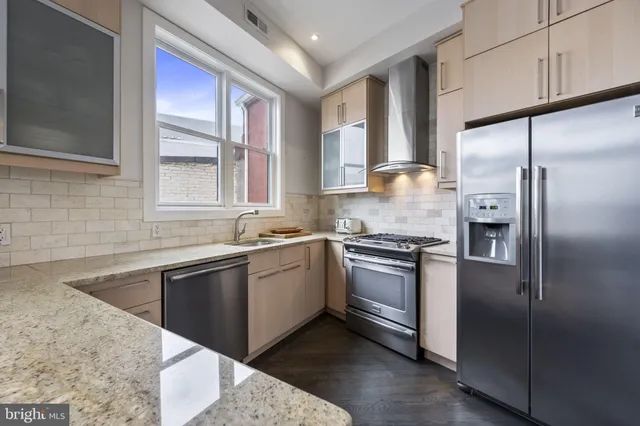 a kitchen with stainless steel appliances granite countertop a sink stove and refrigerator