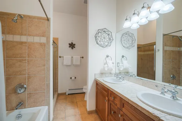 a bathroom with a double vanity sink mirror and shower