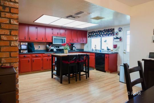 534 South Erin Street Ridgecrest, CA 93555 - Photo 8 of 29 a kitchen with kitchen island granite countertop a sink cabinets and wooden floor