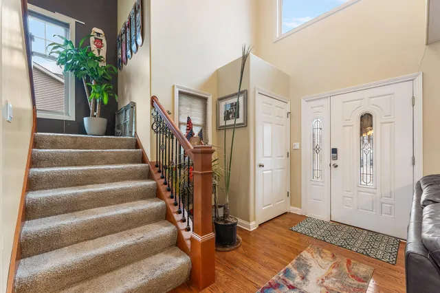 a dining room with wooden floor a chandelier a wooden table and chairs