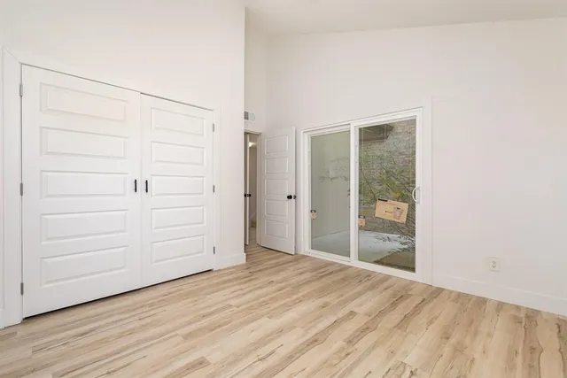 an empty room with wooden floor and cabinet