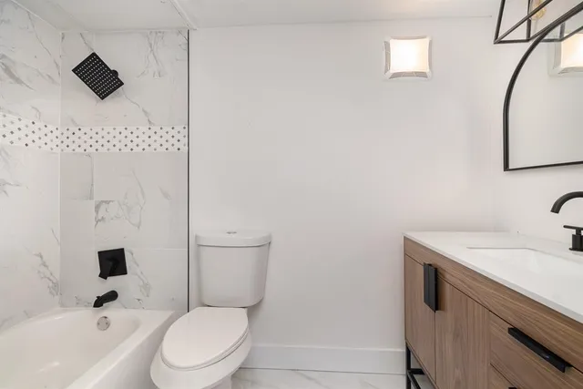 a bathroom with a toilet sink a mirror and shower