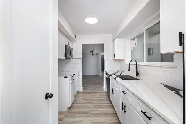 a large white kitchen with stainless steel appliances