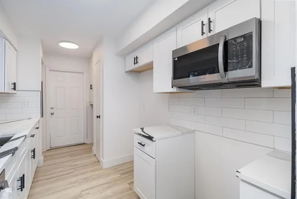 a kitchen with stainless steel appliances white cabinets and a microwave oven