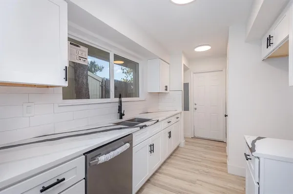 a kitchen with a sink cabinets and wooden floor