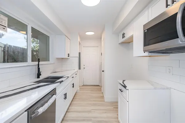 a kitchen with a sink stove and microwave