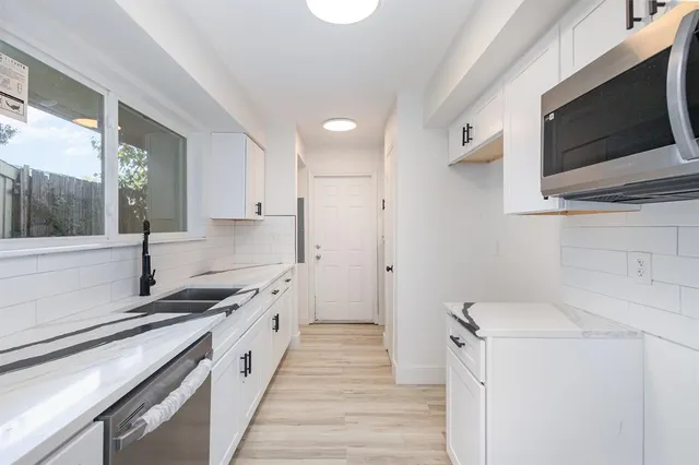a kitchen with a sink stove and microwave