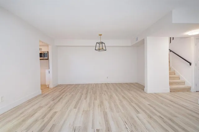 a view of a room with wooden floor and white walls