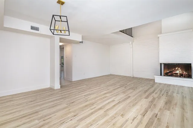 a view of empty room with wooden floor and ceiling fan