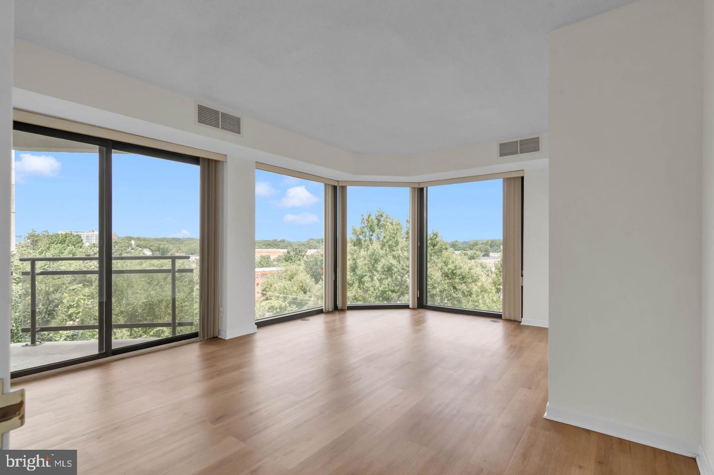 1530 Key Boulevard, Unit 715 Arlington, VA 22209 - Photo 16 of 41 a view of an empty room with wooden floor and a window