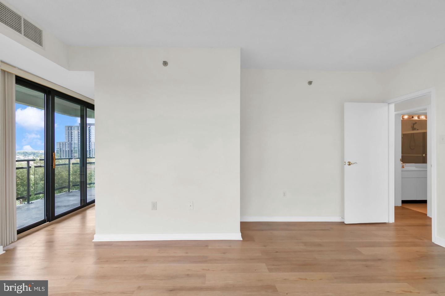 1530 Key Boulevard, Unit 715 Arlington, VA 22209 - Photo 17 of 41 a view of an empty room with wooden floor and a window