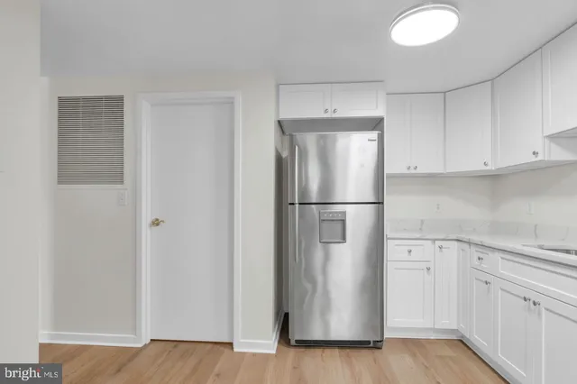 a kitchen with cabinets and a refrigerator