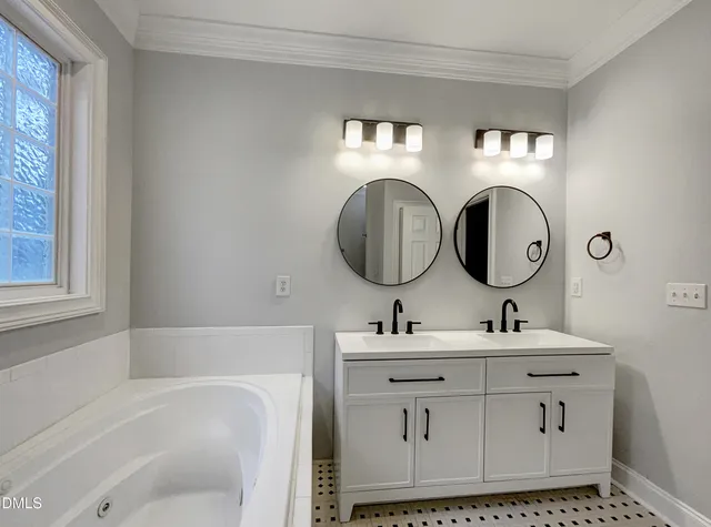 a bathroom with a double vanity sink mirror and bathtub