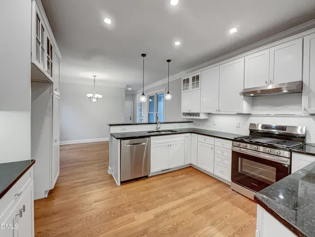 a kitchen with stainless steel appliances granite countertop a stove a sink and a refrigerator
