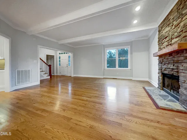 a view of a livingroom with wooden floor and a fireplace