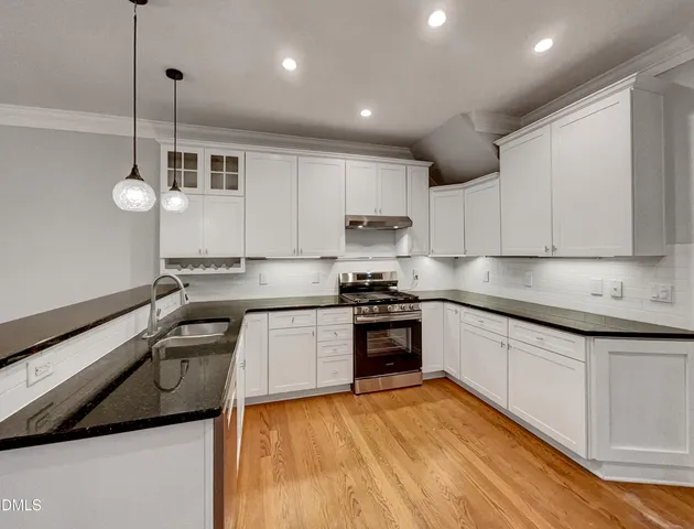 a kitchen with granite countertop a sink cabinets and stainless steel appliances