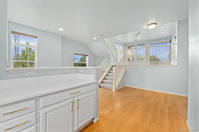 a hallway with white cabinets and wooden floor