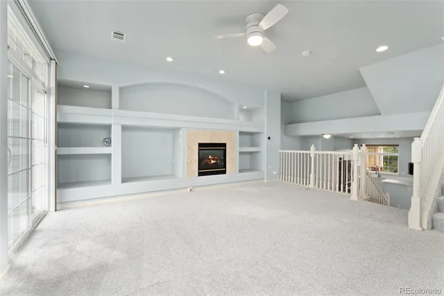 a view of an empty room with a fireplace and a window
