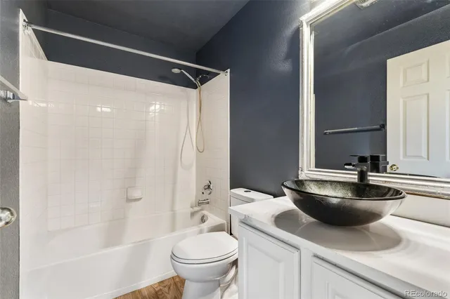 a bathroom with a sink a toilet a mirror and shower