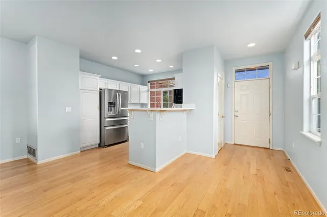 a view of a kitchen with refrigerator and windows