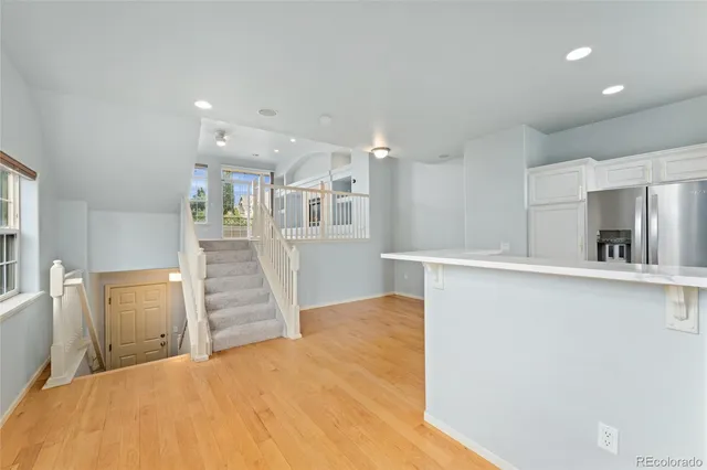 a view of a kitchen with wooden floor and a window