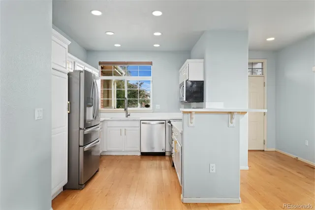 a kitchen with a refrigerator and a stove top oven