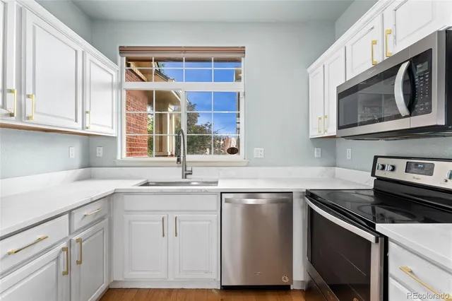 a kitchen with stainless steel appliances granite countertop a sink stove and microwave