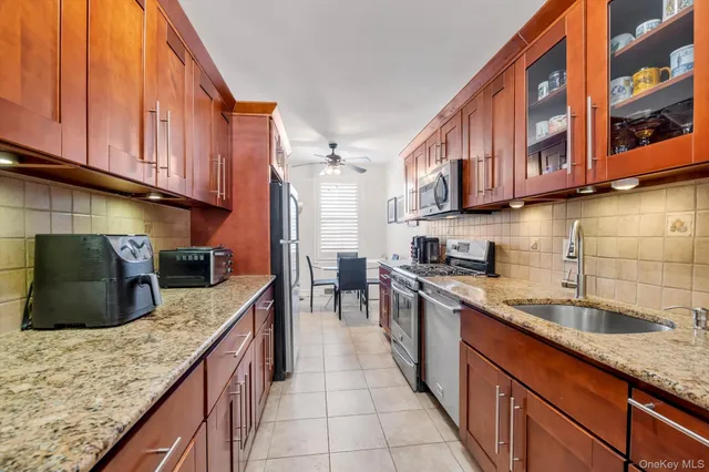 a kitchen with stainless steel appliances granite countertop a sink a stove and cabinets