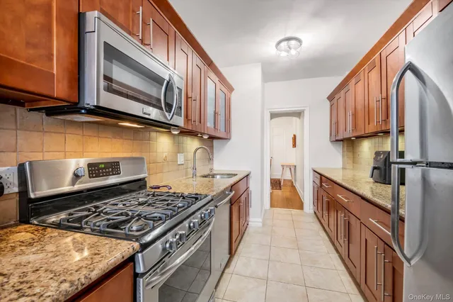 a kitchen with stainless steel appliances granite countertop a stove and a microwave