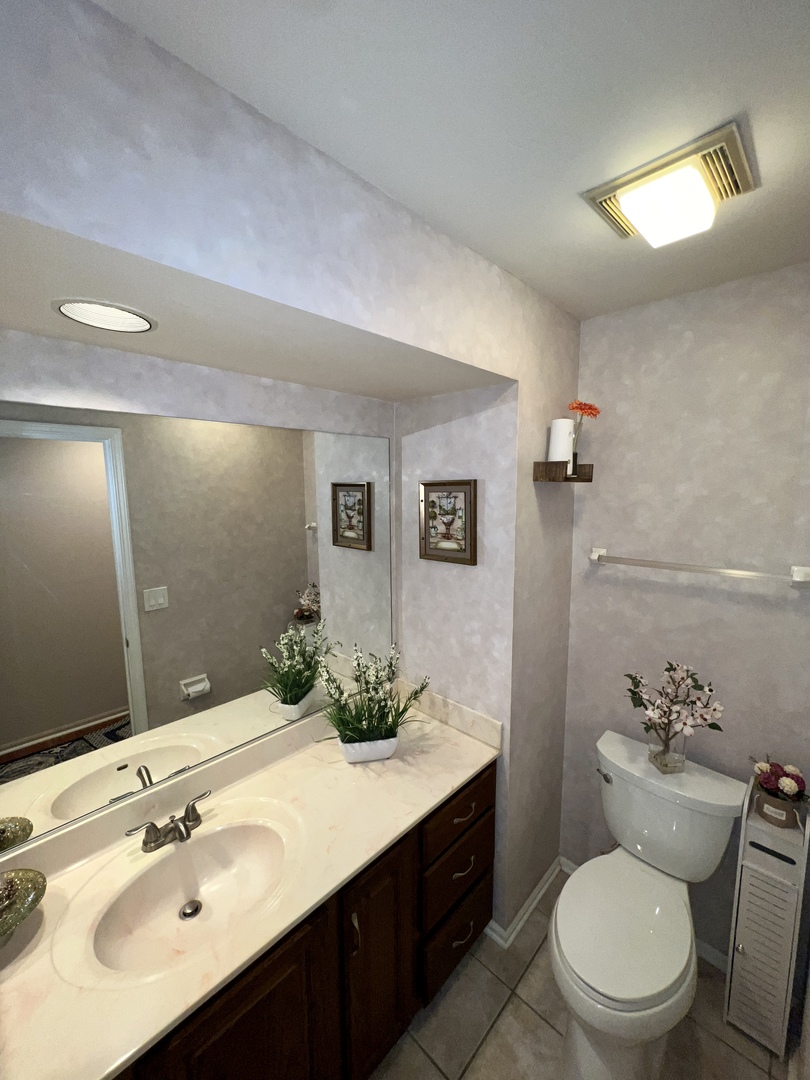 815 Suffield Square Lincolnshire, IL 60069 - Photo 18 of 27 a bathroom with a sink vanity mirror and toilet