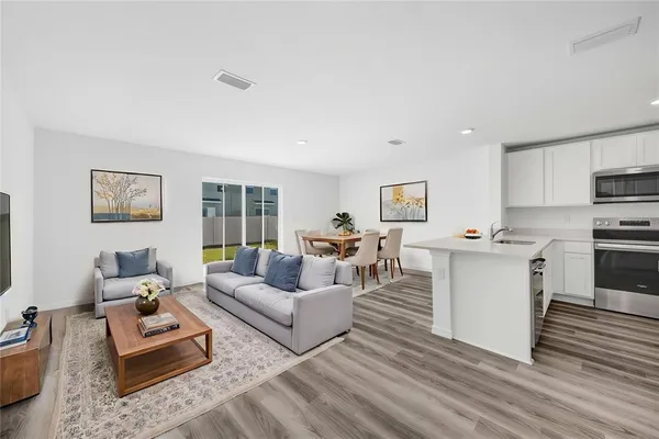 a open kitchen with white cabinets and stainless steel appliances