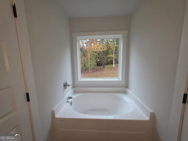a white bath tub sitting in a bathroom next to a window