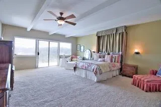 a spacious bedroom with a bed and a chandelier