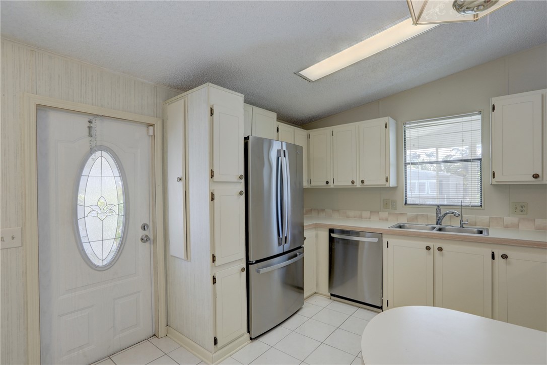 818 Tamarind Circle Sebastian, FL 32976 - Photo 11 of 31 a kitchen with stainless steel appliances granite countertop a refrigerator sink and cabinets