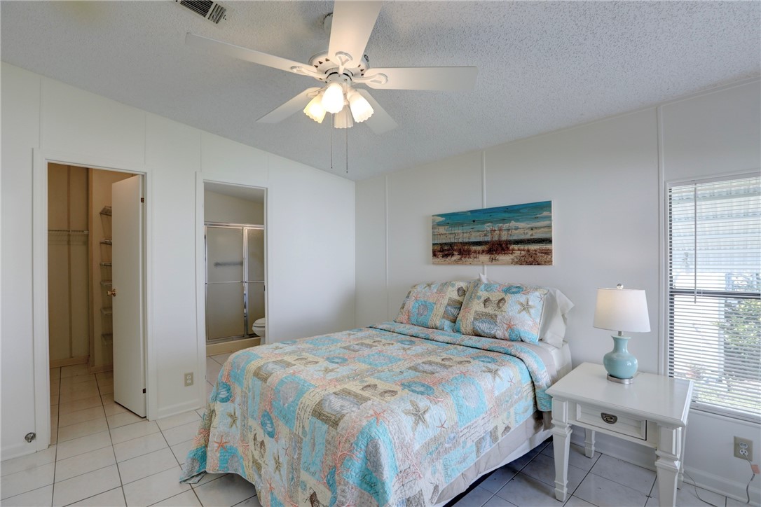 818 Tamarind Circle Sebastian, FL 32976 - Photo 12 of 31 a bedroom with a bed and a chandelier